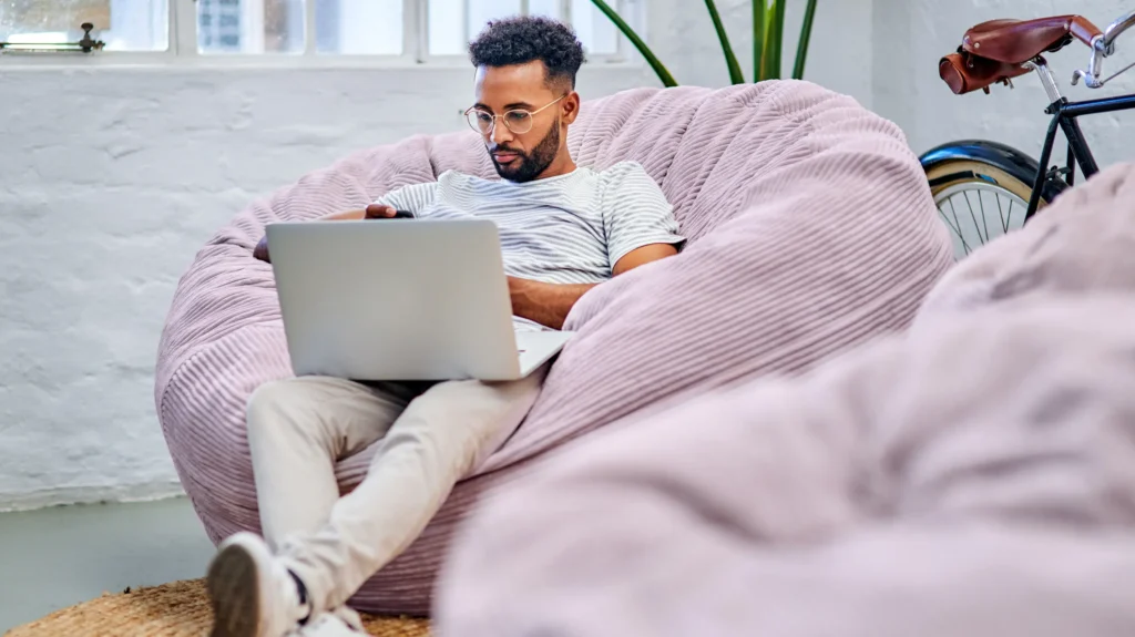 Person som arbetar med laptop i en avslappnad miljö, som symboliserar Prosavios långsiktiga principer för bolagsbyggande och entreprenörskap.