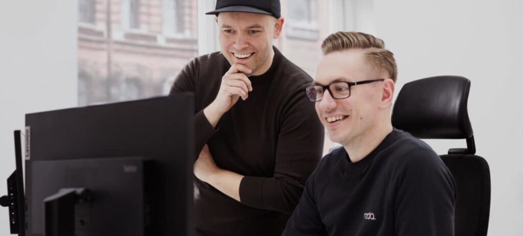 Två personer vid dator som symboliserar Redas digitala lösningar för effektiv fakturahantering och ekonomiadministration.